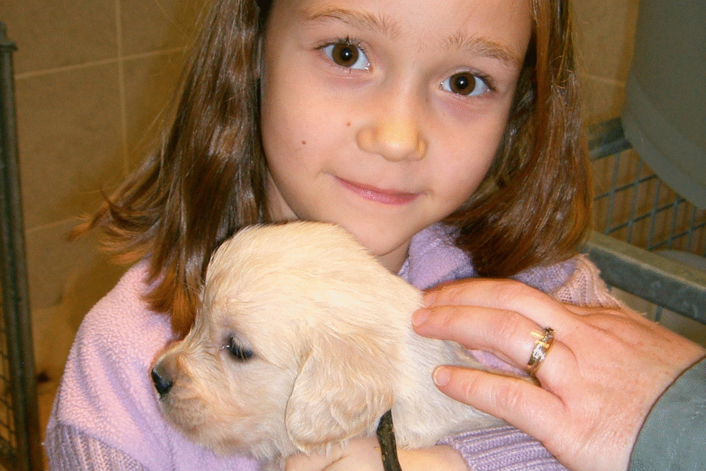 Une enfant avec un chiot golden retriever dans les bras