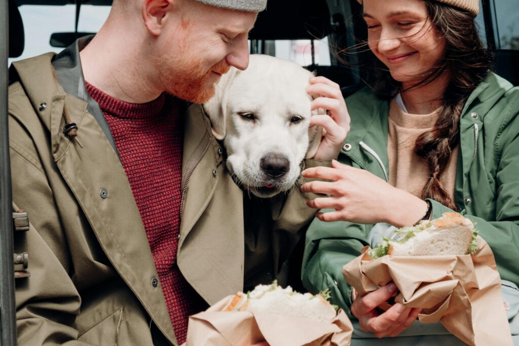 Chien qui mange un sandwich avec deux humains